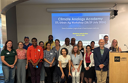 Group photo of workshop participants in front of a projected slide titled Climate Analogs Academy STL Urban Ag Workshop.